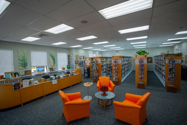 interior space featuring dark colored carpet and a paneled ceiling