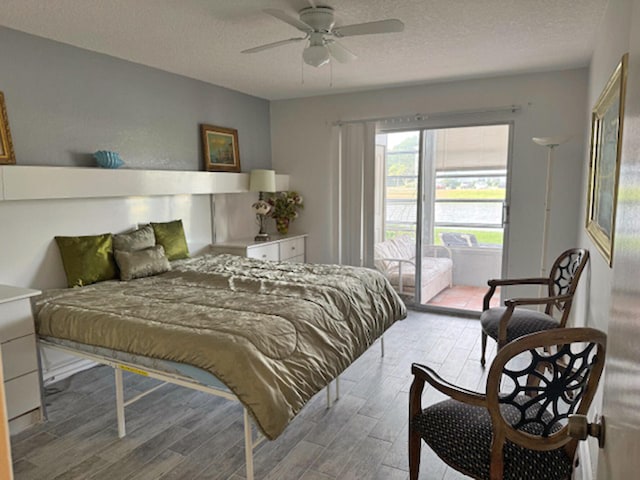 bedroom with access to exterior, light hardwood / wood-style flooring, a textured ceiling, and ceiling fan