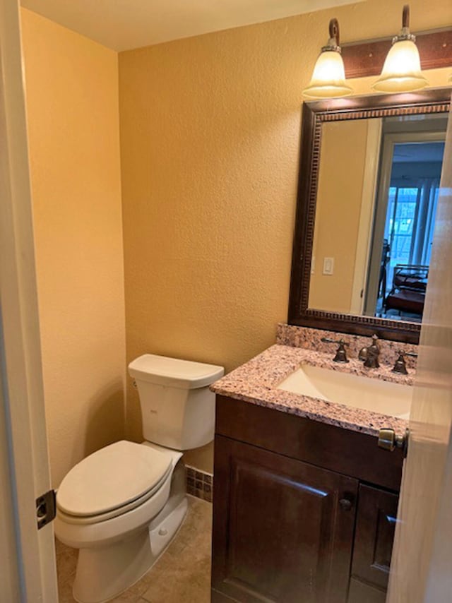 bathroom featuring tile patterned floors, vanity, and toilet