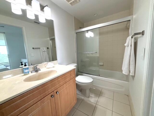 full bathroom with tile patterned flooring, vanity, toilet, and shower / bath combination with glass door