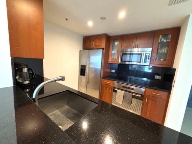 kitchen with appliances with stainless steel finishes, tasteful backsplash, and sink