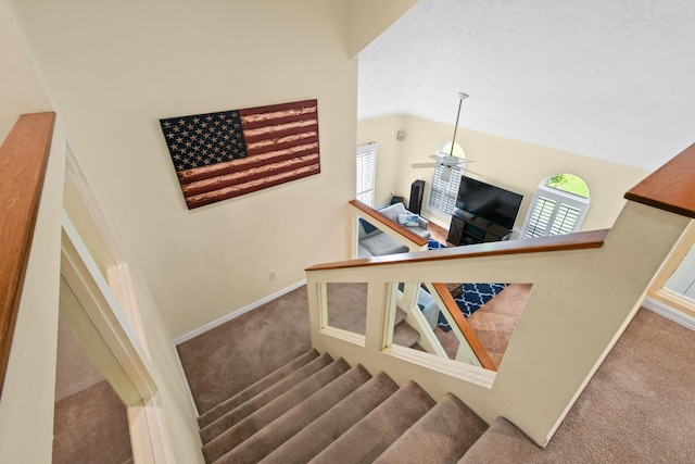 stairway with carpet floors, lofted ceiling, and baseboards