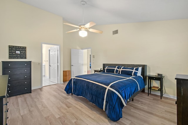 bedroom featuring baseboards, visible vents, a ceiling fan, light wood-type flooring, and high vaulted ceiling