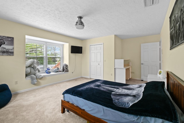 bedroom with a textured ceiling, carpet flooring, visible vents, and baseboards