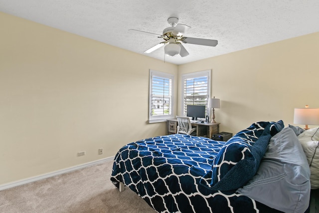 carpeted bedroom with ceiling fan, baseboards, and a textured ceiling