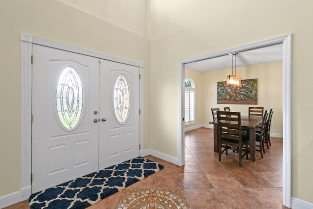 entrance foyer with light tile patterned floors and baseboards