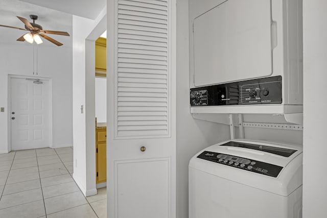 laundry area featuring ceiling fan, light tile patterned flooring, and stacked washer / drying machine