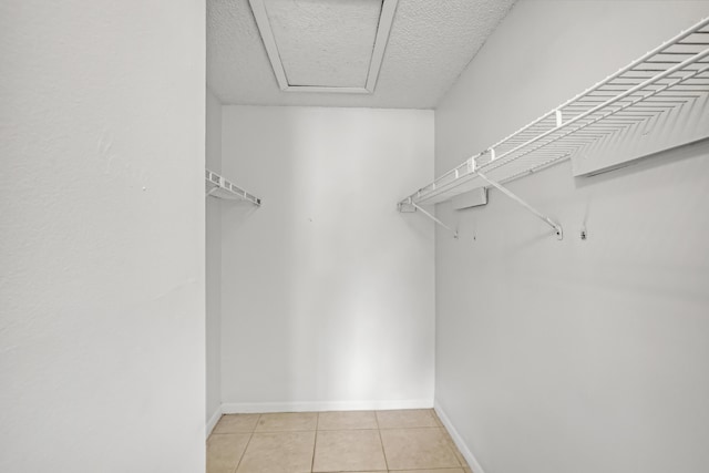 walk in closet with light tile patterned floors