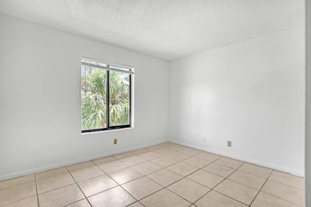 spare room with light tile patterned flooring and a textured ceiling