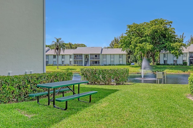 surrounding community featuring a water view and a lawn