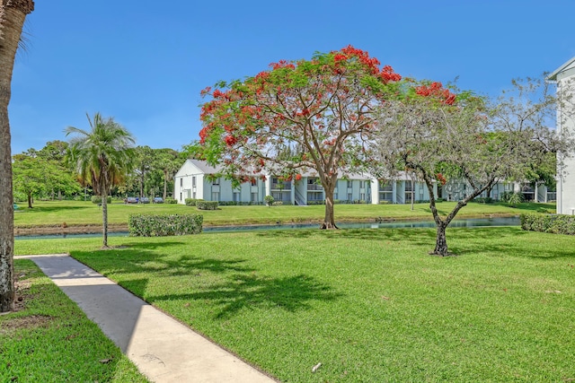 surrounding community with a yard and a water view