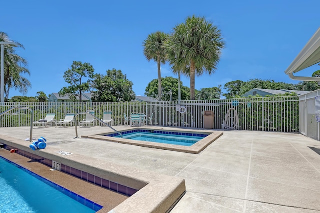 view of pool with a patio and a hot tub