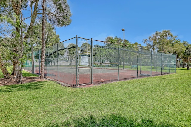 view of tennis court featuring a yard