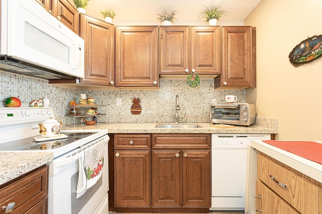 kitchen with decorative backsplash, white appliances, and sink