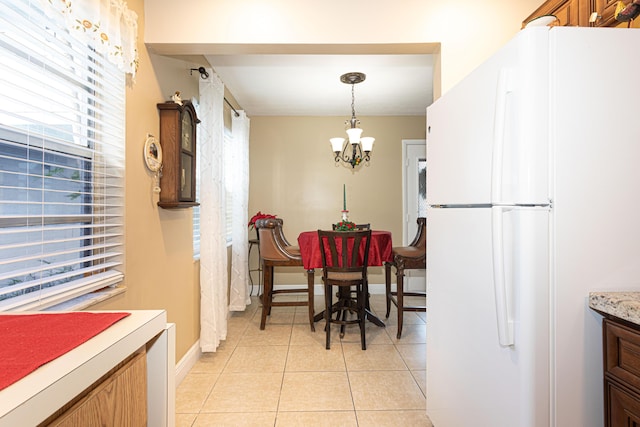 tiled dining space featuring a notable chandelier