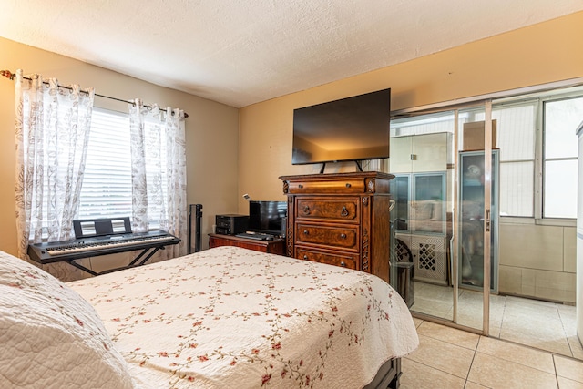 bedroom with a closet, light tile patterned floors, and a textured ceiling