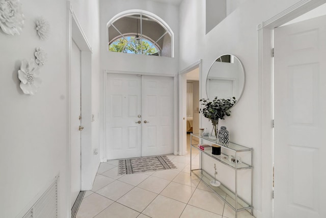 entrance foyer featuring light tile patterned floors and a high ceiling