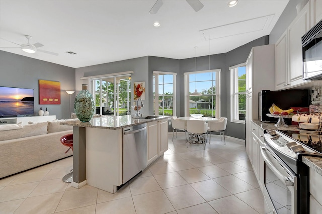 kitchen featuring white cabinetry, sink, stainless steel dishwasher, white range with electric cooktop, and an island with sink