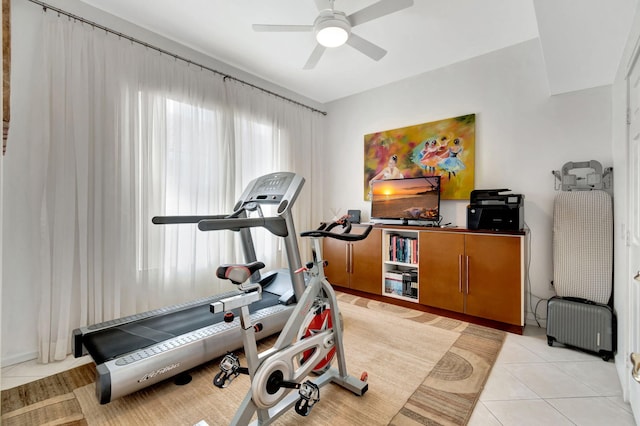 workout room with ceiling fan, light tile patterned floors, and radiator