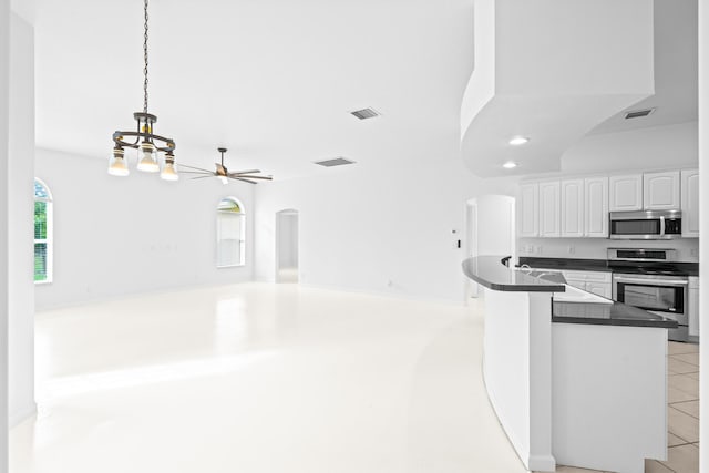 kitchen featuring white cabinetry, stainless steel appliances, kitchen peninsula, pendant lighting, and ceiling fan with notable chandelier