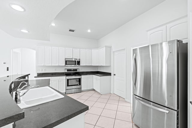 kitchen with white cabinetry, sink, light tile patterned flooring, and appliances with stainless steel finishes