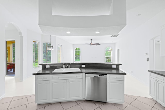 kitchen with stainless steel dishwasher, a healthy amount of sunlight, white cabinets, and sink