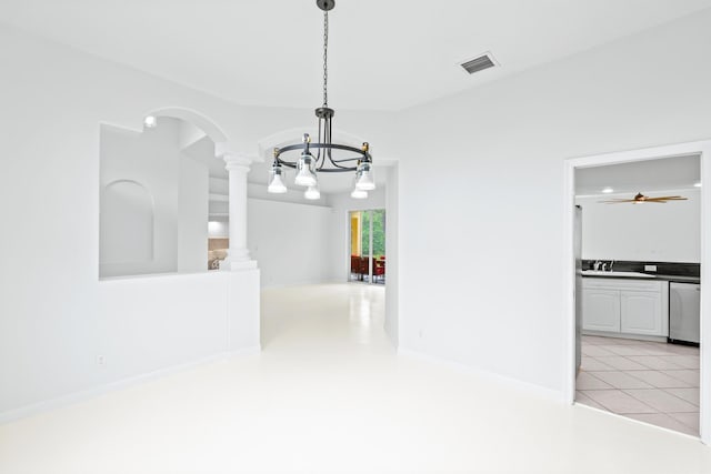 interior space with a chandelier, light tile patterned floors, sink, and decorative columns