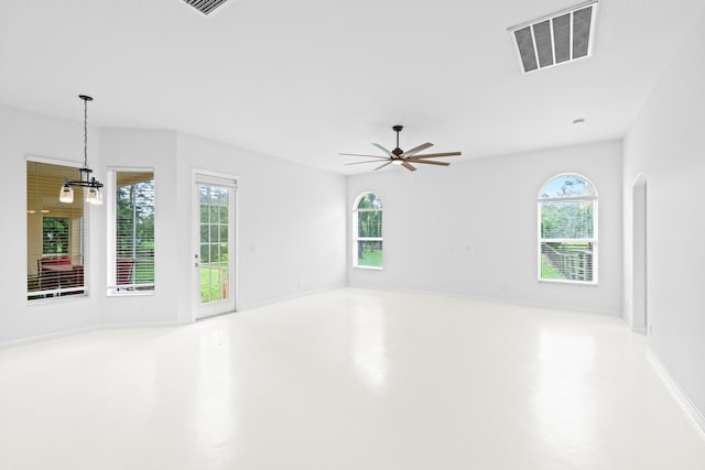 spare room featuring concrete flooring, ceiling fan, and a healthy amount of sunlight