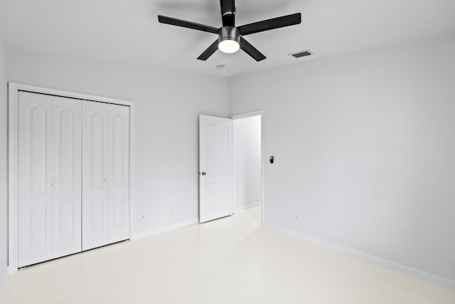 unfurnished bedroom with ceiling fan and a closet