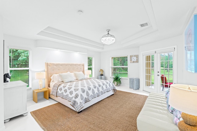 bedroom with light carpet, french doors, access to outside, and a tray ceiling