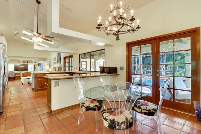 tiled dining space featuring ceiling fan, french doors, and high vaulted ceiling