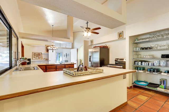 kitchen with high vaulted ceiling, sink, hanging light fixtures, appliances with stainless steel finishes, and kitchen peninsula