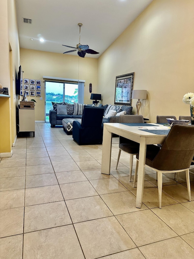 tiled dining space featuring high vaulted ceiling and ceiling fan