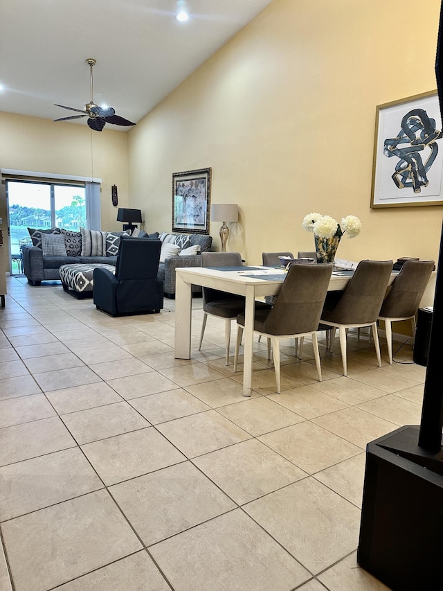 dining area featuring ceiling fan, high vaulted ceiling, and light tile patterned floors