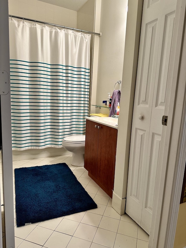 bathroom with tile patterned flooring, vanity, and toilet