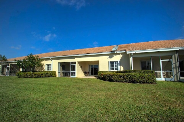 rear view of property featuring a lawn