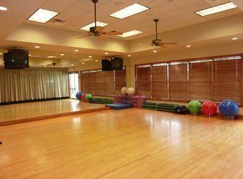 workout area featuring ceiling fan, a tray ceiling, and hardwood / wood-style floors