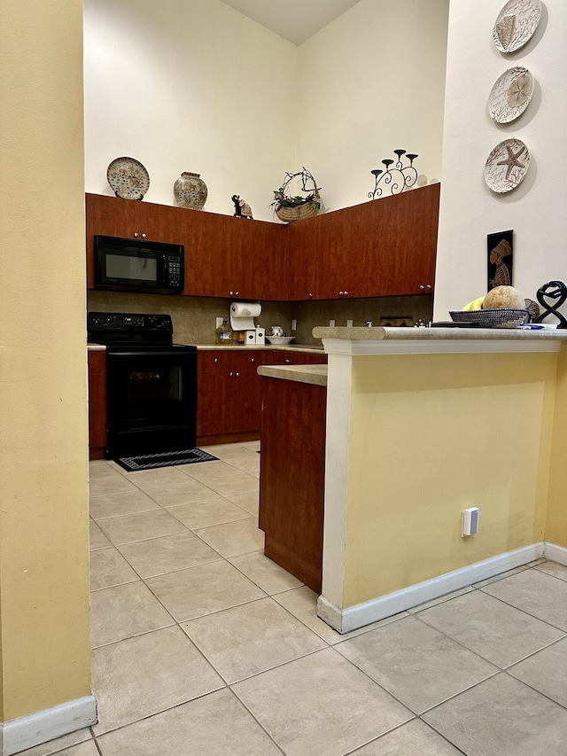 kitchen featuring light tile patterned flooring, a breakfast bar, black appliances, kitchen peninsula, and a high ceiling