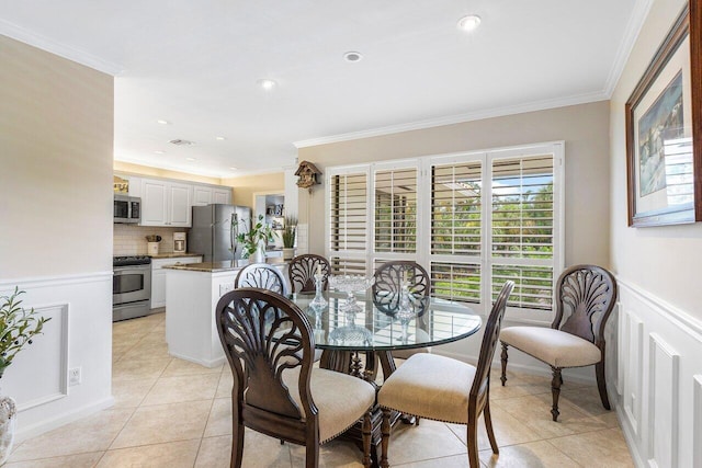 dining space featuring light tile patterned floors and crown molding