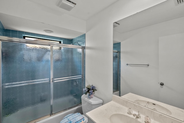 full bathroom featuring vanity, shower / bath combination with glass door, and toilet