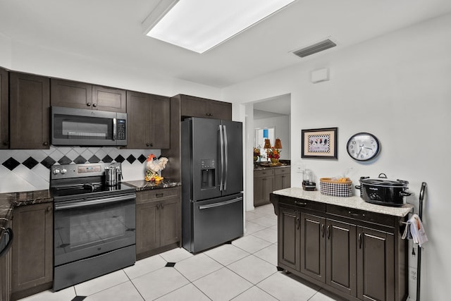 kitchen with electric range, dark brown cabinets, fridge with ice dispenser, light tile patterned flooring, and decorative backsplash