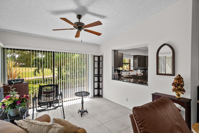 living room featuring light tile patterned flooring, lofted ceiling, sink, and a textured ceiling