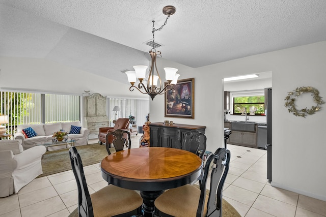 dining room featuring sink, an inviting chandelier, vaulted ceiling, a textured ceiling, and light tile patterned floors