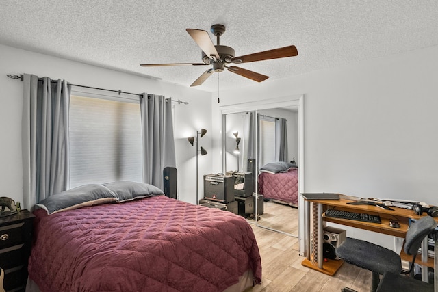 bedroom featuring multiple windows, a textured ceiling, and light wood-type flooring