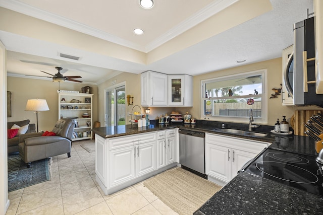 kitchen featuring stainless steel appliances, kitchen peninsula, sink, and white cabinets