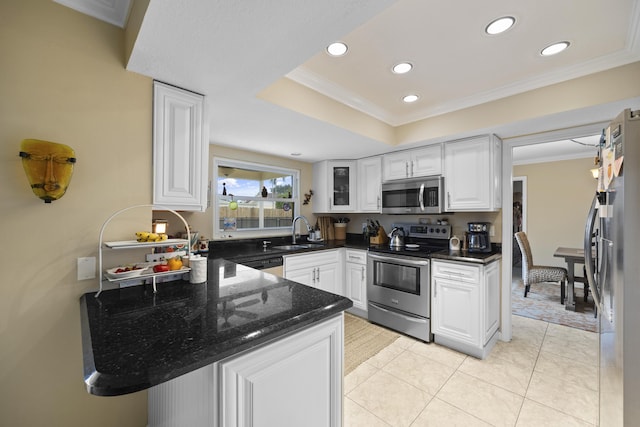 kitchen featuring appliances with stainless steel finishes, kitchen peninsula, sink, and white cabinets