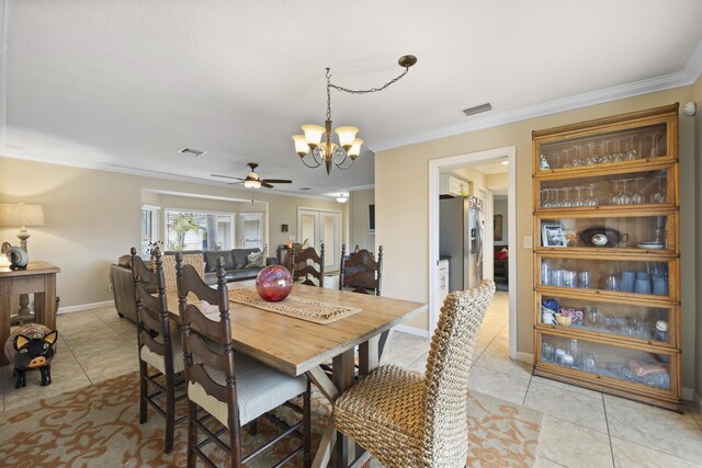 dining area featuring crown molding, ceiling fan with notable chandelier, and light tile patterned flooring