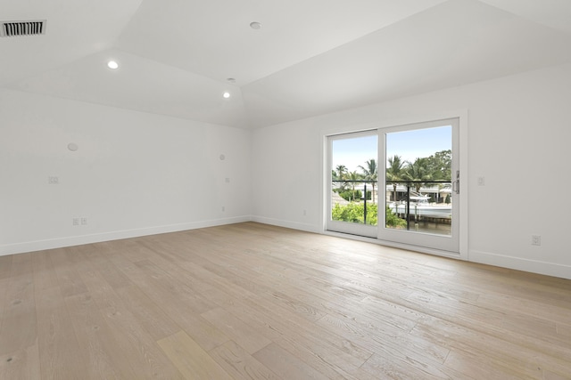 unfurnished room with light hardwood / wood-style floors and vaulted ceiling