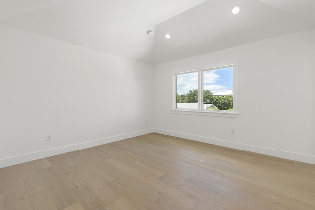 empty room with light hardwood / wood-style floors and lofted ceiling