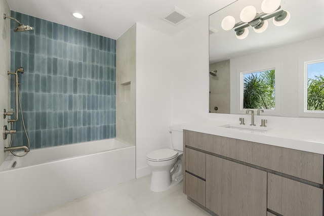 full bathroom featuring tile patterned flooring, tiled shower / bath combo, toilet, and vanity